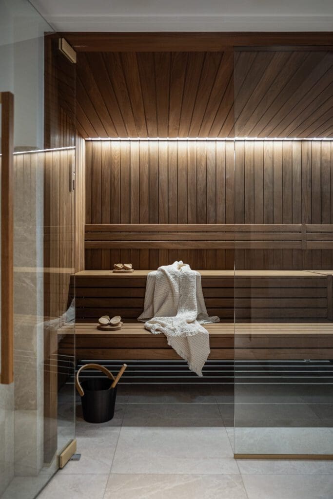 A wooden bench with a towel and slippers.